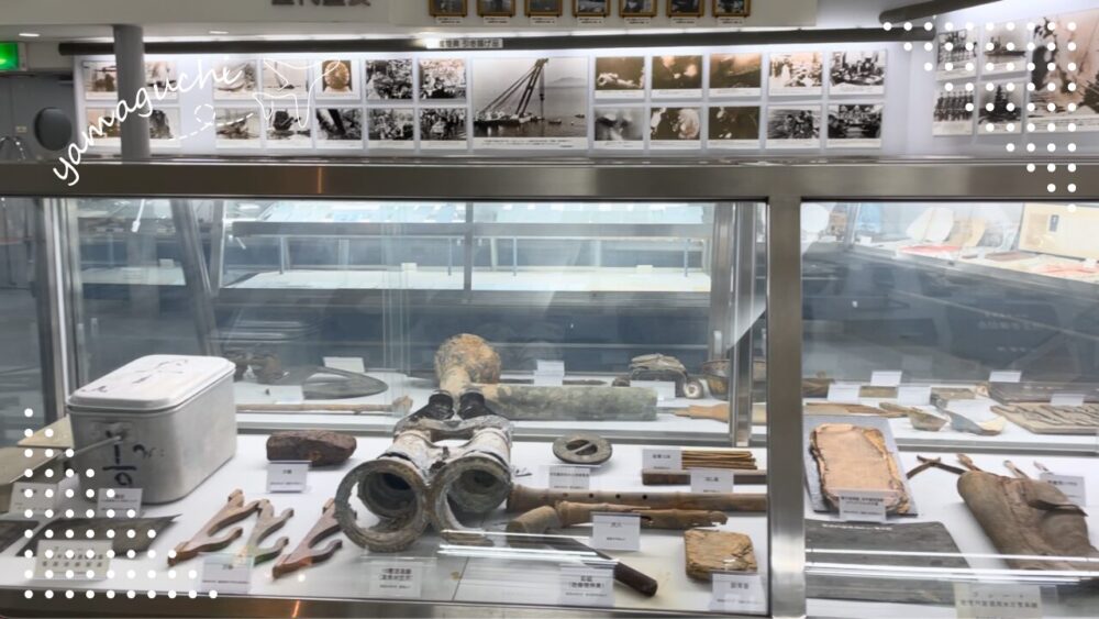 引き上げ作業の写真パネルと遺品の数々
